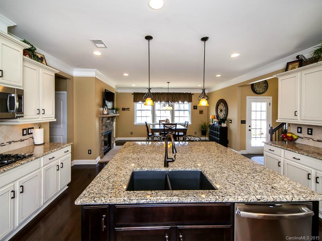 930 Solandra Way Tega Cay, SC 29708 - Photo 10 of 24 a kitchen with stainless steel appliances granite countertop a sink a stove and a wooden cabinets