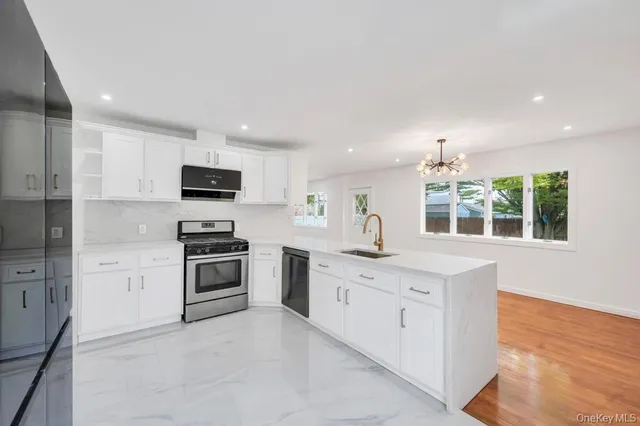 a kitchen with white cabinets stainless steel appliances and sink