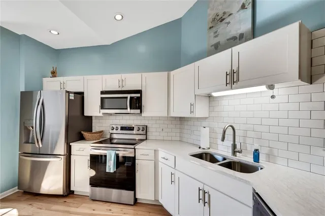 a kitchen with stainless steel appliances granite countertop a refrigerator and a stove
