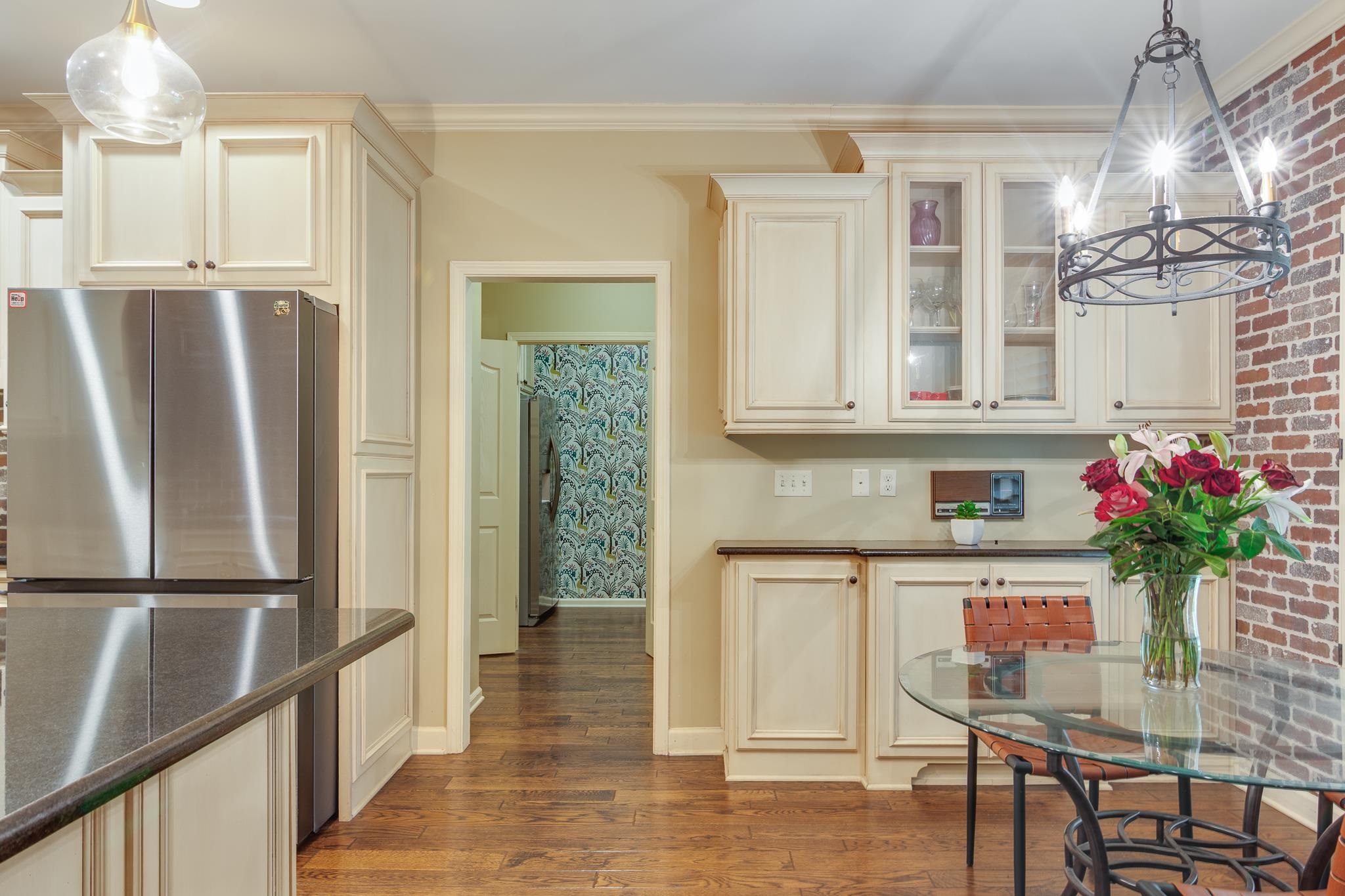 791 North Tree Drive Collierville, TN 38017 - Photo 7 of 27 Kitchen featuring wood-finish flooring, cream-toned cabinetry with glass-front accents, and a stainless steel refrigerator