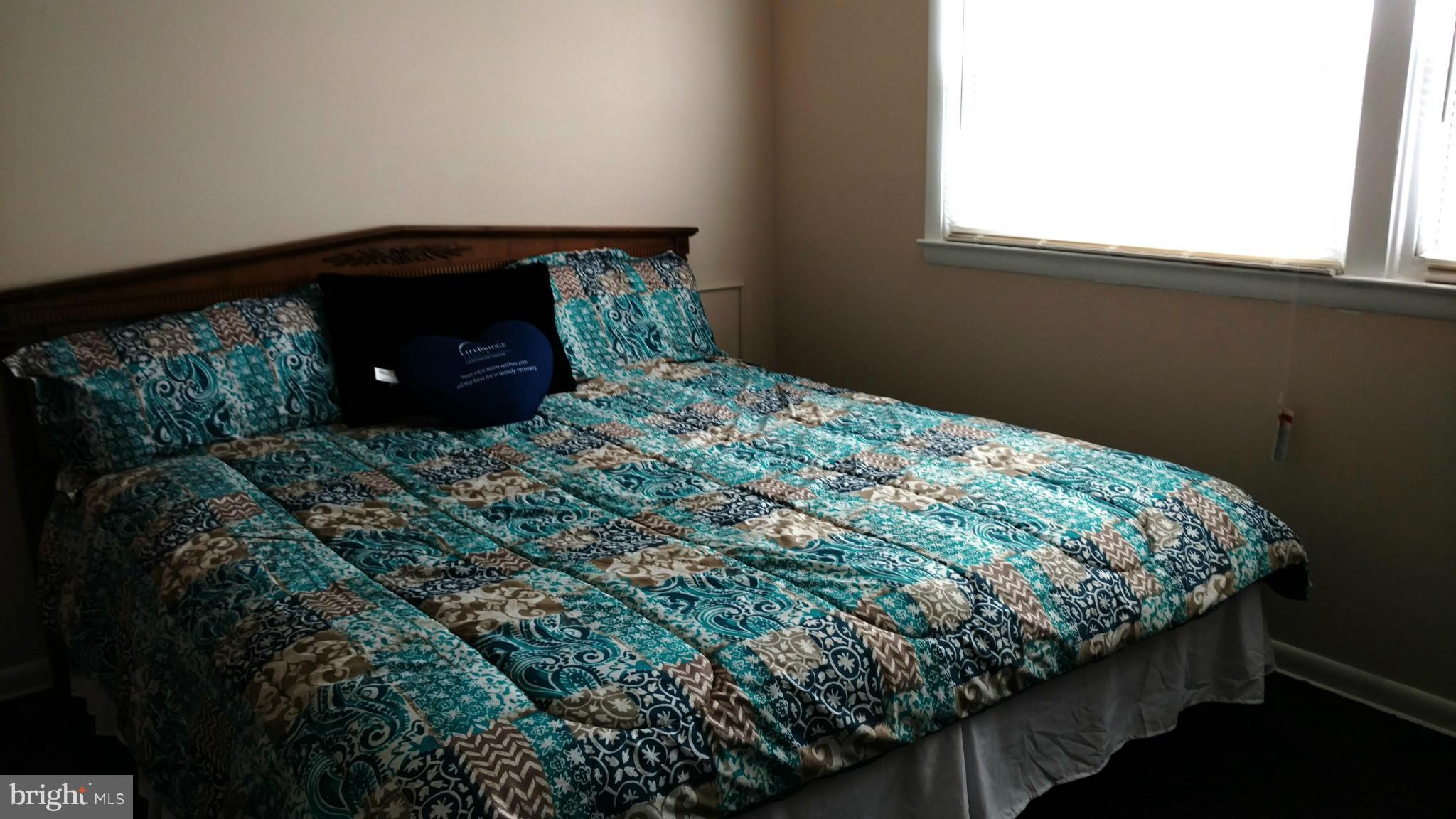7136 Bexhill Road Baltimore, MD 21244 - Photo 11 of 27 a bed sitting in a bedroom next to a window