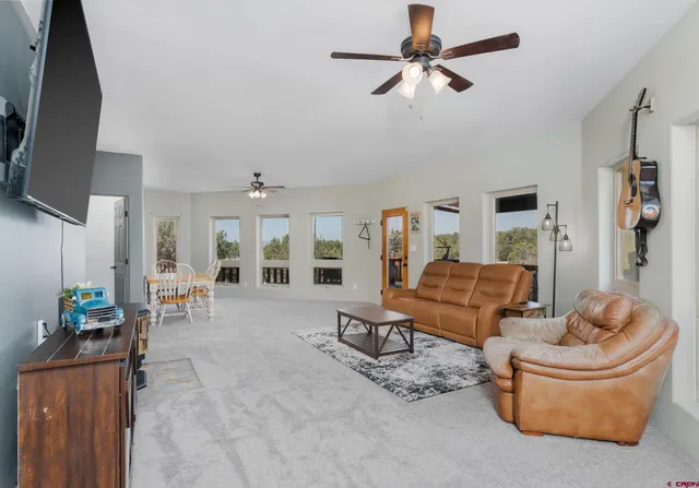 a view of a livingroom with furniture and a ceiling fan