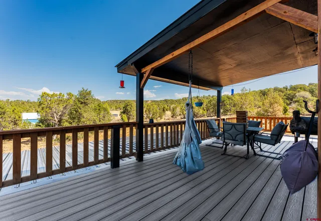 a view of a balcony with chairs and wooden floor