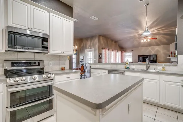 a kitchen with a stove a sink and a microwave