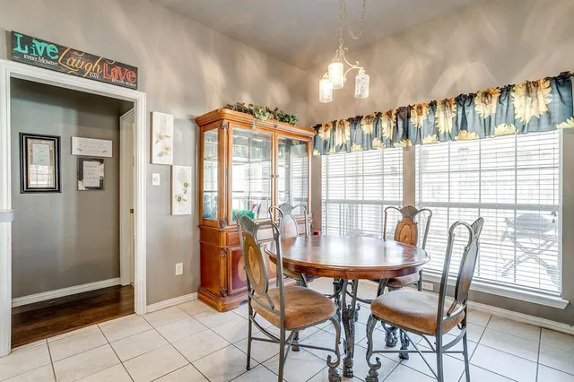 a dining room with furniture and large windows
