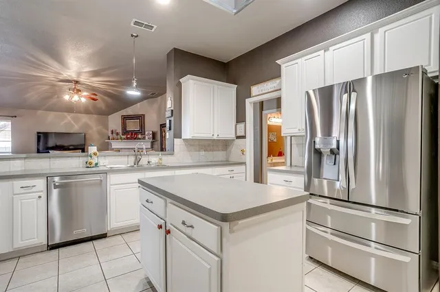 a kitchen with cabinets stainless steel appliances and a counter space