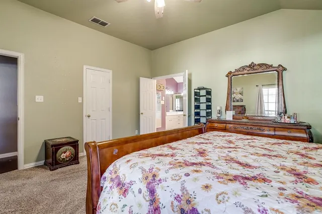 a bedroom with a bed and a large mirror on dresser