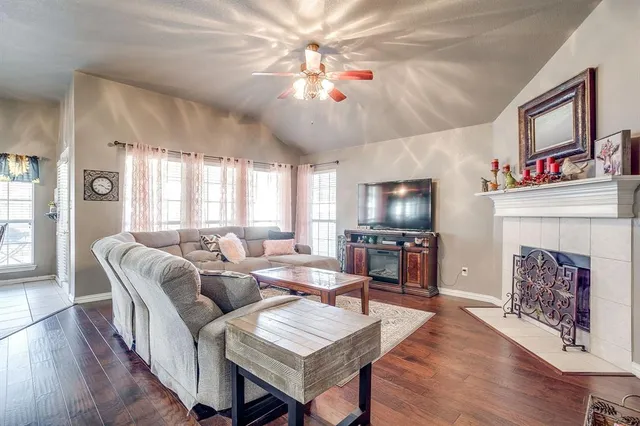 a living room with furniture a flat screen tv and a fireplace