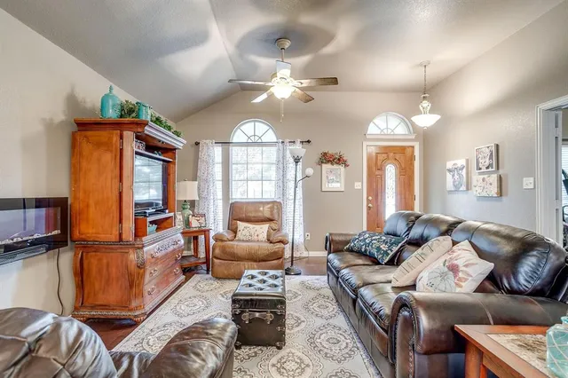 a living room with furniture ceiling fan and a window