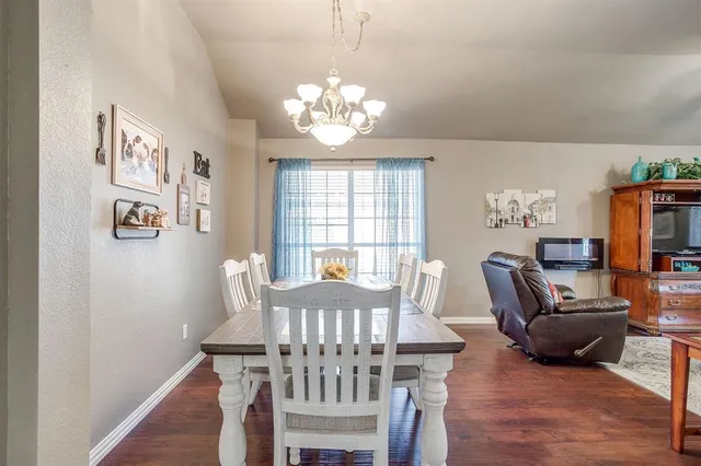 a view of a dining room with furniture a chandelier and wooden floor