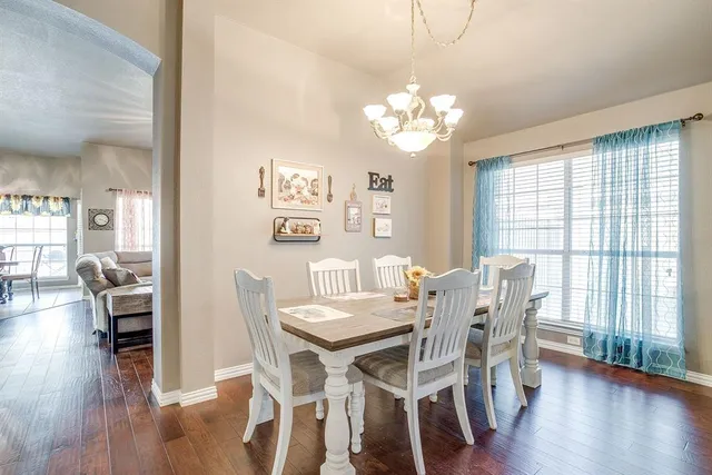 a view of a dining room with furniture wooden floor and chandelier