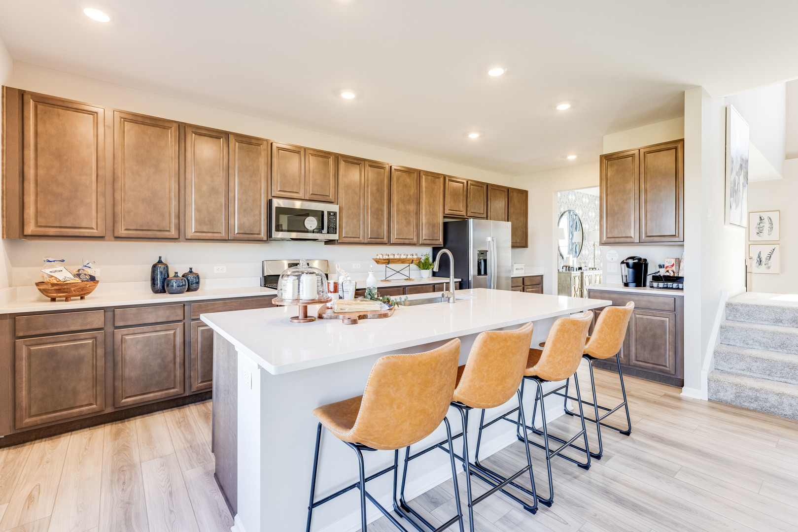 707 Erwin Street Oswego, IL 60543 - Photo 5 of 18 a kitchen with stainless steel appliances granite countertop a stove top oven a sink a refrigerator and white cabinets with wooden floor