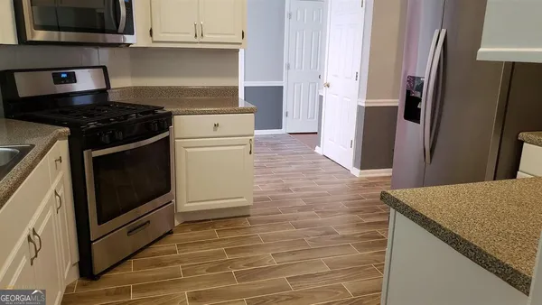 a kitchen with granite countertop a stove and a refrigerator