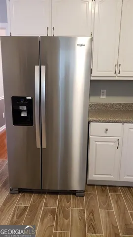 a view of a refrigerator in kitchen and cabinets