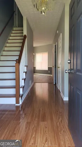 a view of entryway and hall with wooden floor