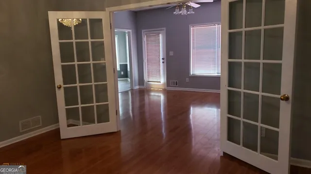 an empty room with wooden floor and windows