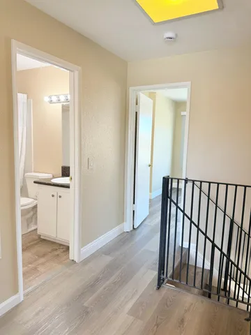 a view of a hallway with a dining room & wooden floor and a sink