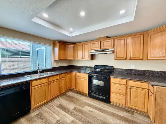 a kitchen with stainless steel appliances granite countertop a stove sink and cabinets