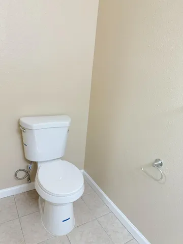a white toilet sitting next to a white wall