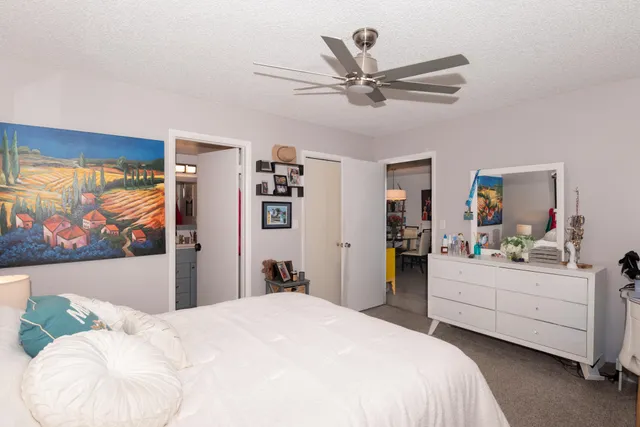 a bedroom with a bed and a painting on the wall