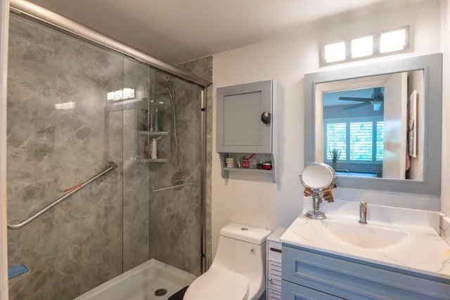 a bathroom with a sink toilet a mirror and shower