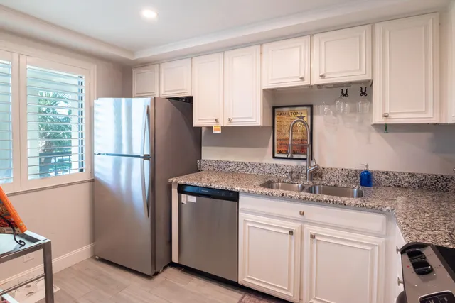 a kitchen with stainless steel appliances granite countertop a refrigerator sink and cabinets
