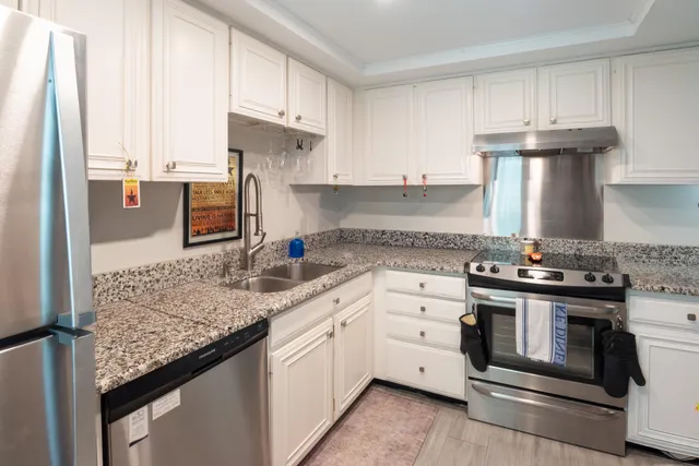 a kitchen with stainless steel appliances granite countertop a stove and a sink