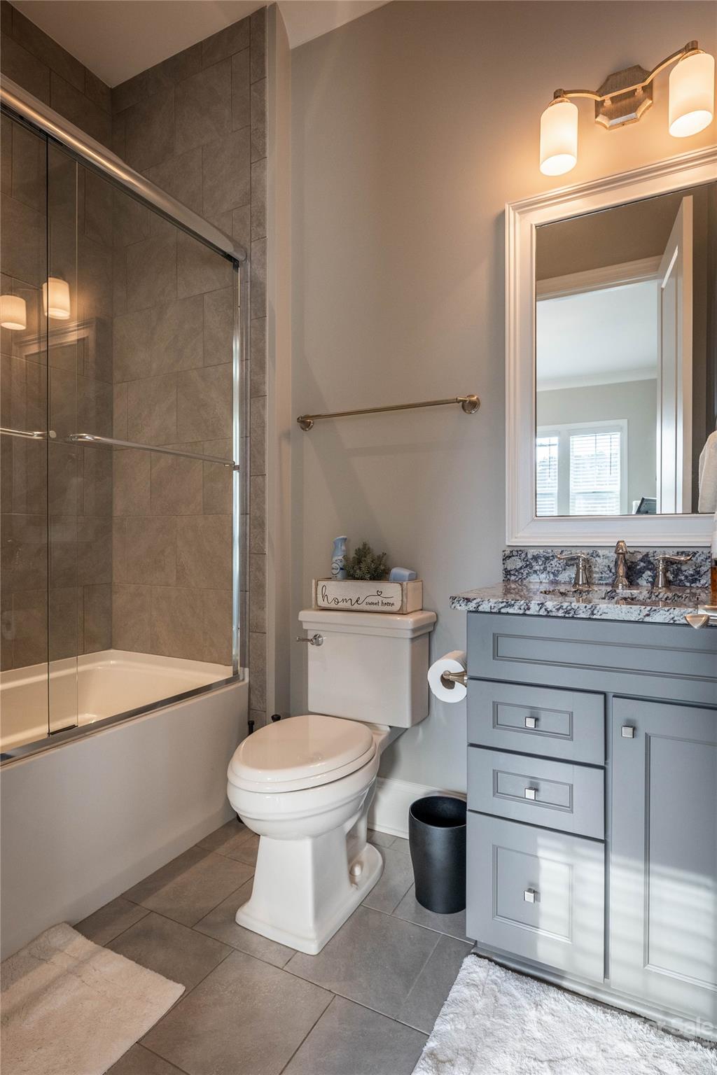 9110 Greenwood Road Terrell, NC 28682 - Photo 18 of 42 a bathroom with a granite countertop toilet a sink and a bathtub