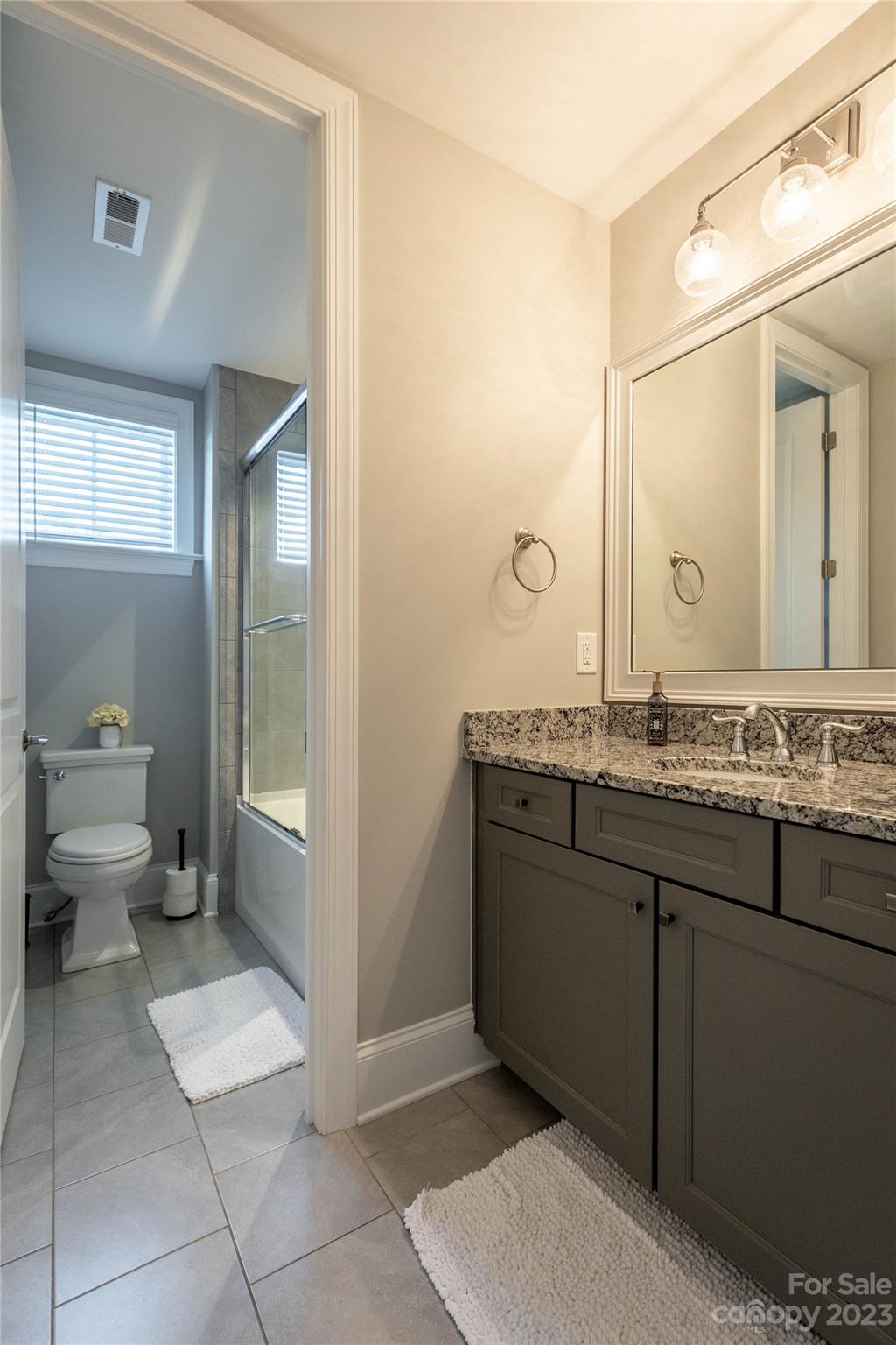 9110 Greenwood Road Terrell, NC 28682 - Photo 27 of 42 a bathroom with a granite countertop sink a toilet and a mirror