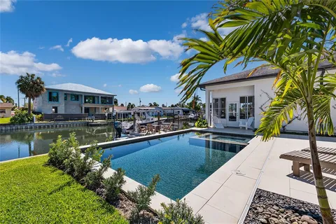 a view of a house with pool and chairs