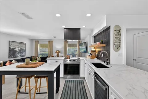 a kitchen with a stove a sink dishwasher and a refrigerator with wooden floor