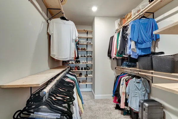 a view of walk in closet with clothes and shoes