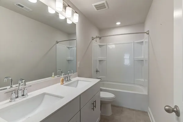 a bathroom with a shower sink vanity mirror and toilet