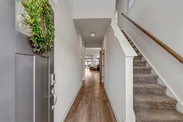 a view of a hallway with wooden floor and stairs