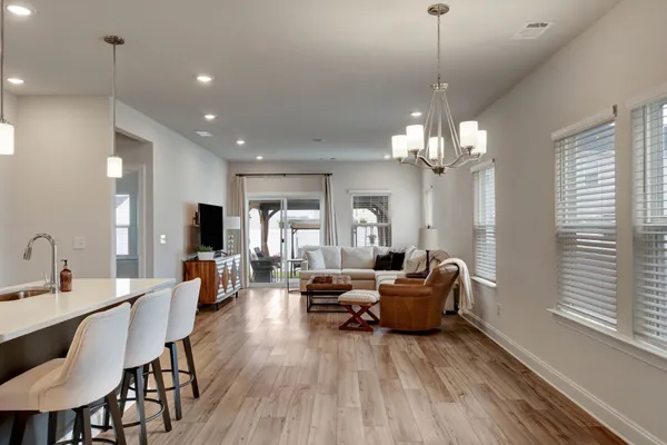 a living room with furniture a chandelier and a dining room