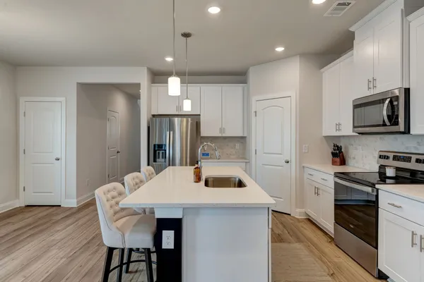 a kitchen with a table chairs refrigerator and microwave