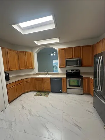a large kitchen with a large counter top stainless steel appliances and cabinets