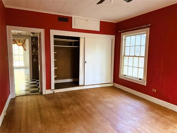 an empty room with wooden floor and a window
