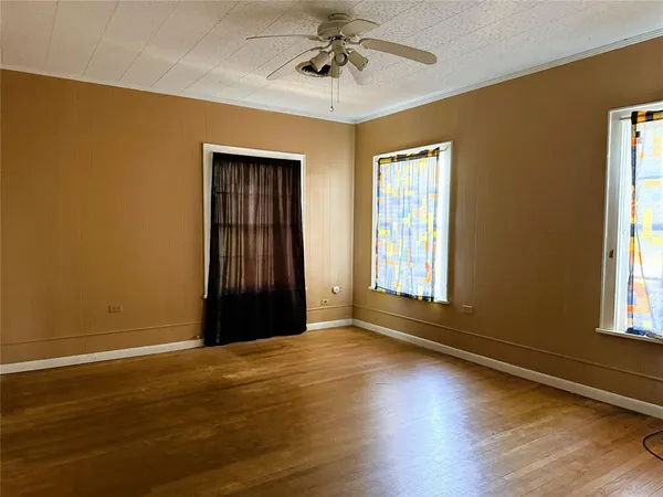 a view of an empty room with wooden floor