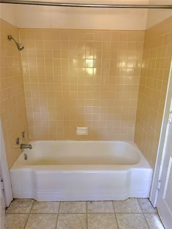 an empty room with wooden floor and windows with curtains