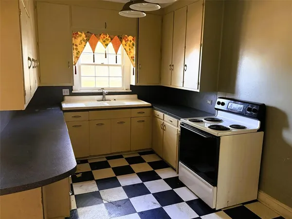 a kitchen with a stove a sink and a window