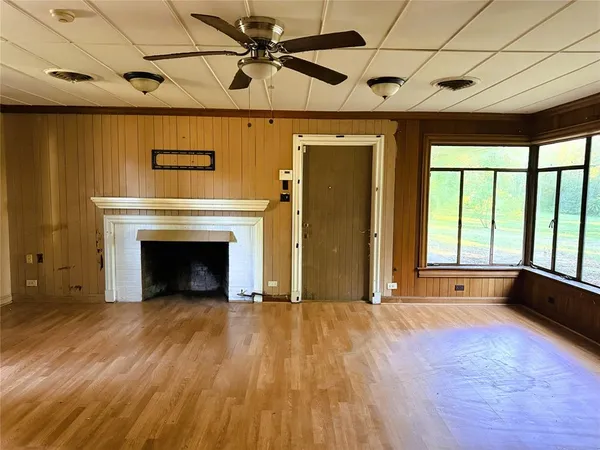 a view of an empty room with a fireplace and a window