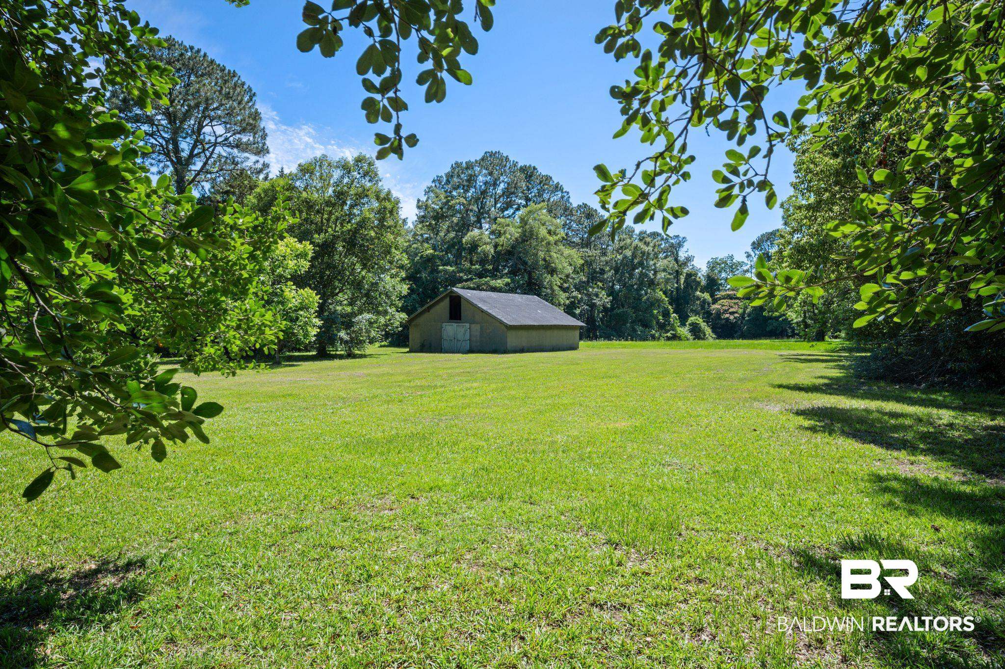950 Walter Smith Road Mobile, AL 36695 - Photo 35 of 51 View of grassy yard featuring a pole building and an outdoor structure
