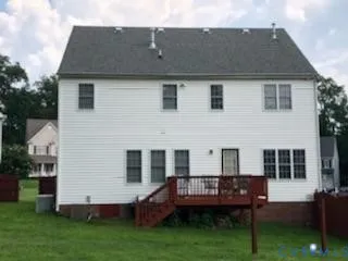 a view of house with a yard and sitting area
