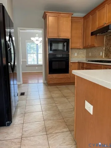 a kitchen with a refrigerator and a stove top oven