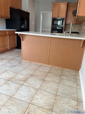 a kitchen with stainless steel appliances a sink a stove top oven a counter space and cabinets