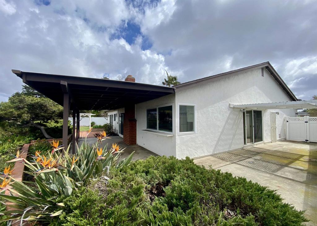 664 Mariposa Circle Chula Vista, CA 91911 - Photo 2 of 34 a backyard of a house with table and chairs under an umbrella