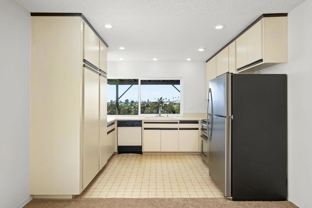 664 Mariposa Circle Chula Vista, CA 91911 - Photo 8 of 34 a kitchen with a refrigerator and white cabinets
