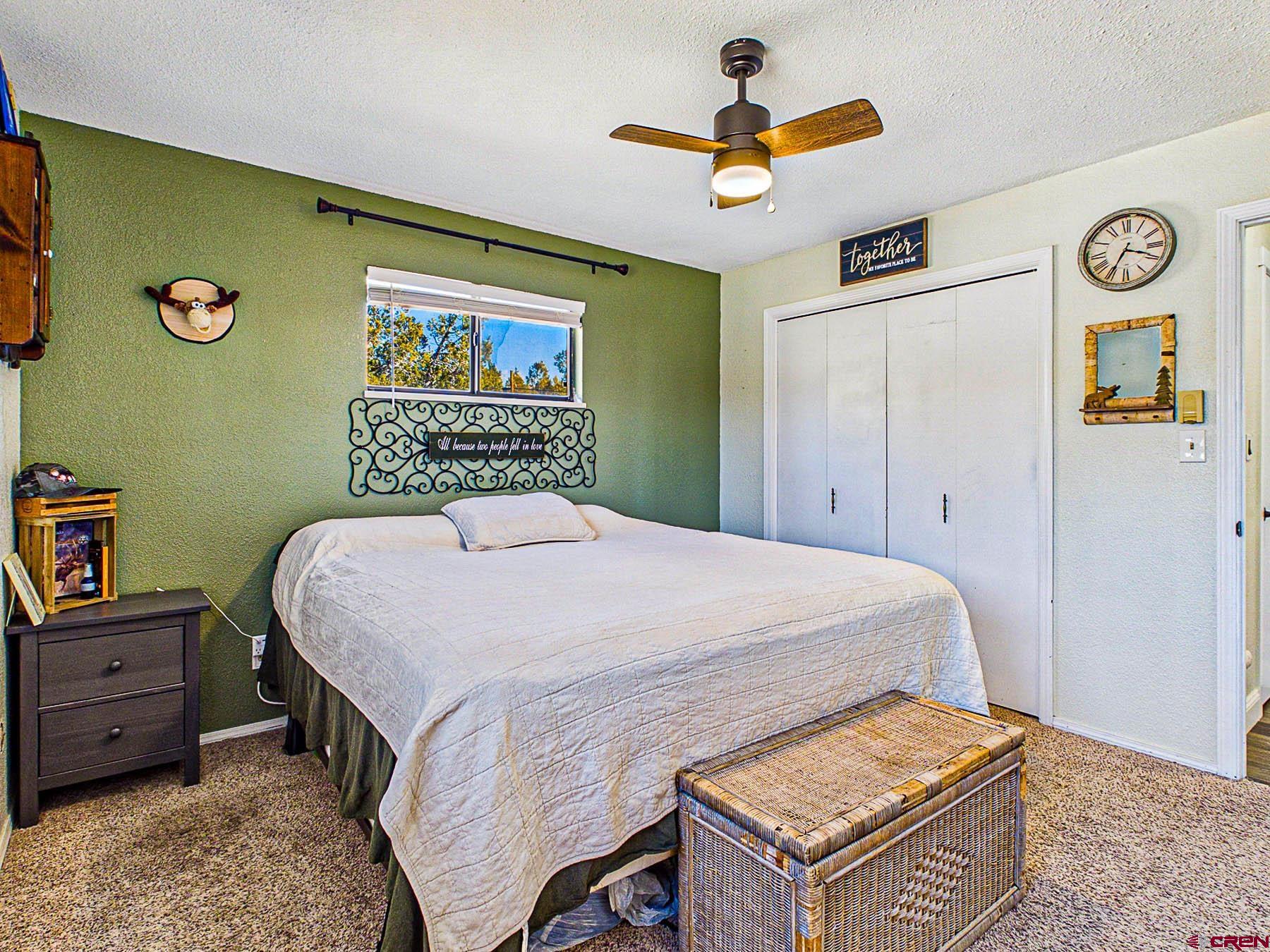 18697 Ward Creek Road Cedaredge, CO 81413 - Photo 23 of 45 a bedroom with a bed and a chandelier