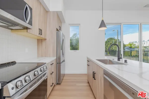 a kitchen with stainless steel appliances granite countertop a sink and a granite counter tops